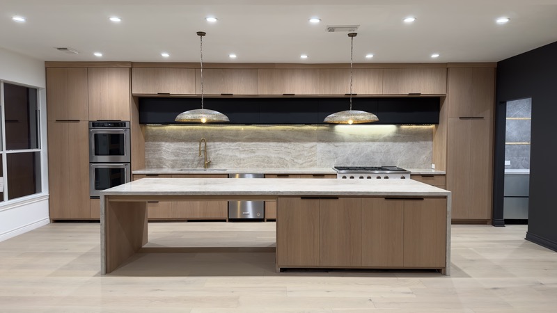 Modern oak flat-panel kitchen with hammered gold pendant lights in Houston
